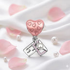 Heart-shaped charm with pink hearts and a pearl on a white background with pink petals and pearls.