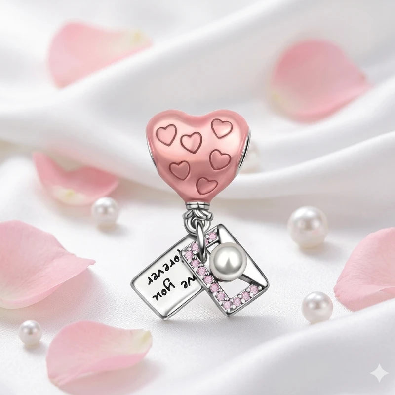 Heart-shaped charm with pink hearts and a pearl on a white background with pink petals and pearls.