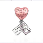 Heart-shaped charm with pink hearts and a pearl on a white background