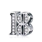 Silver number 18 charm with embedded stones on a white background