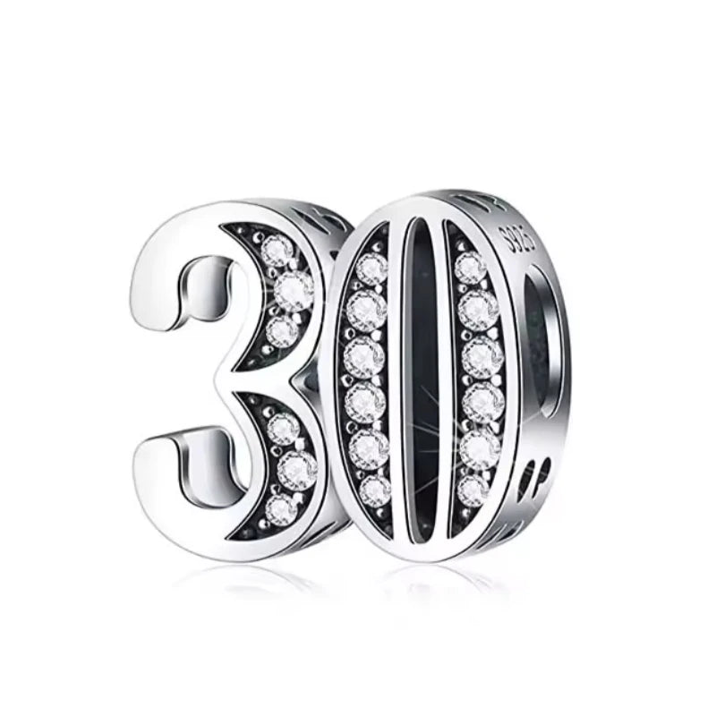 Silver charm with '30' and clear stones on a white background
