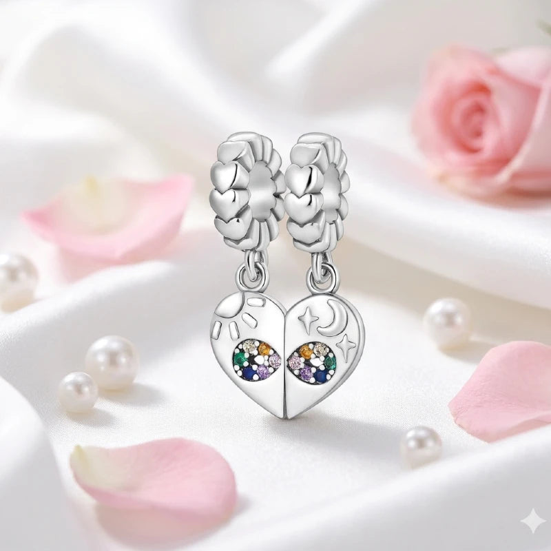 Silver heart-shaped earrings with gemstones on a white surface with pink flowers.